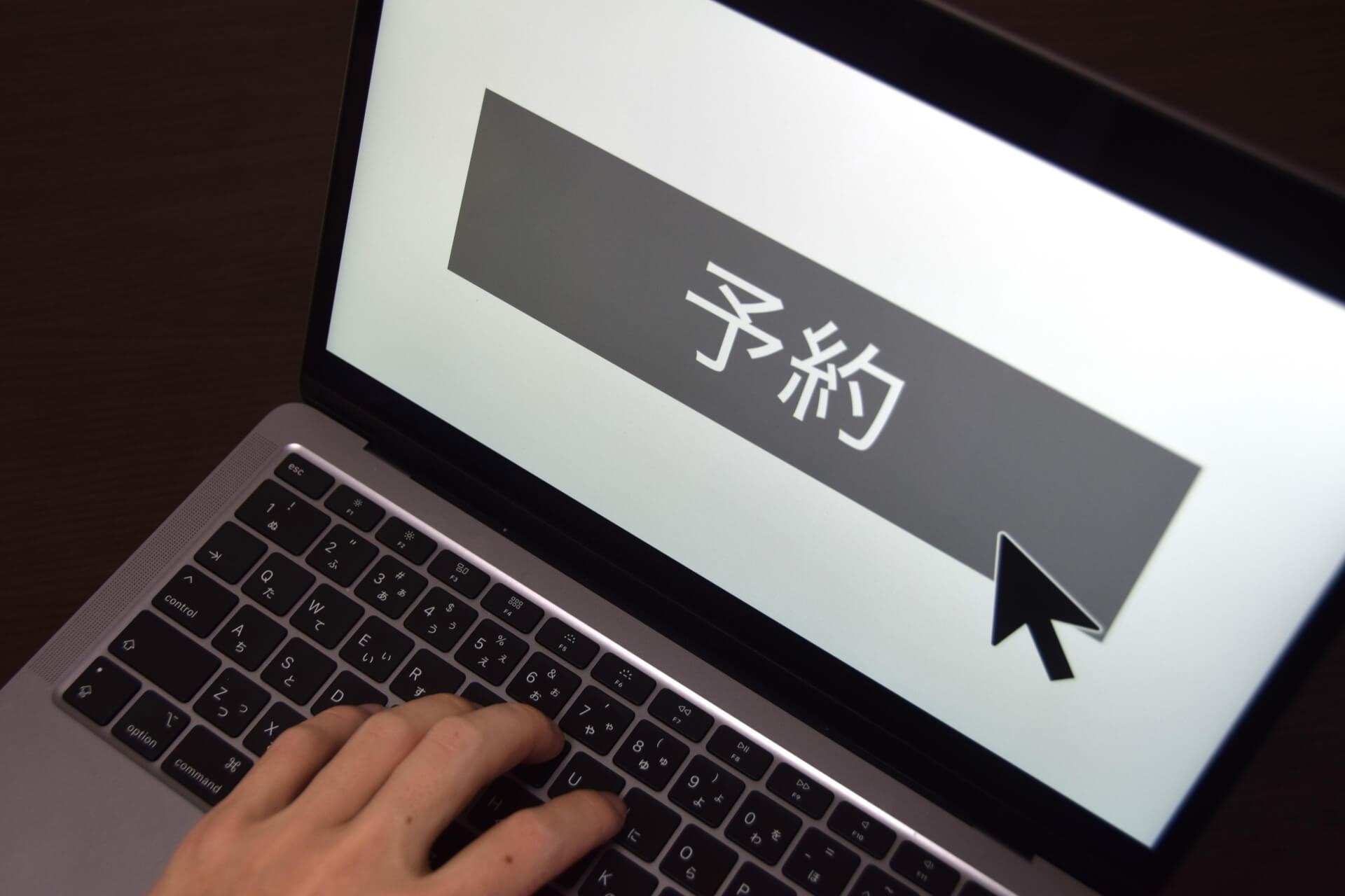 予約ボタンをクリックする手